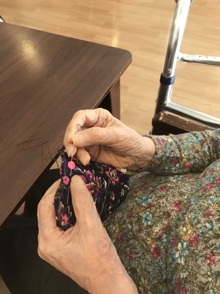布を縫う女性