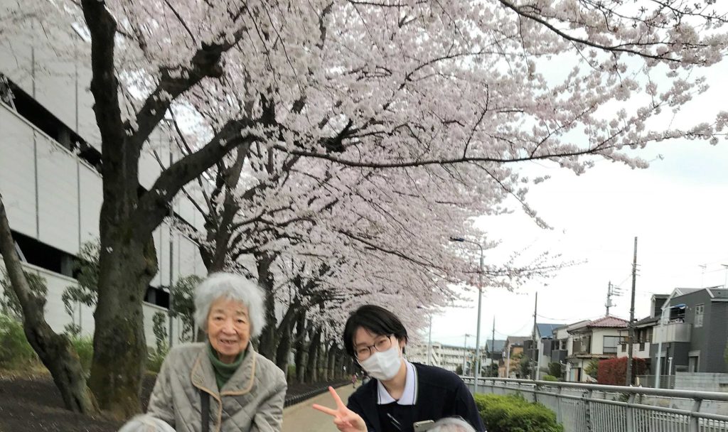 桜の前に立つ女性二人