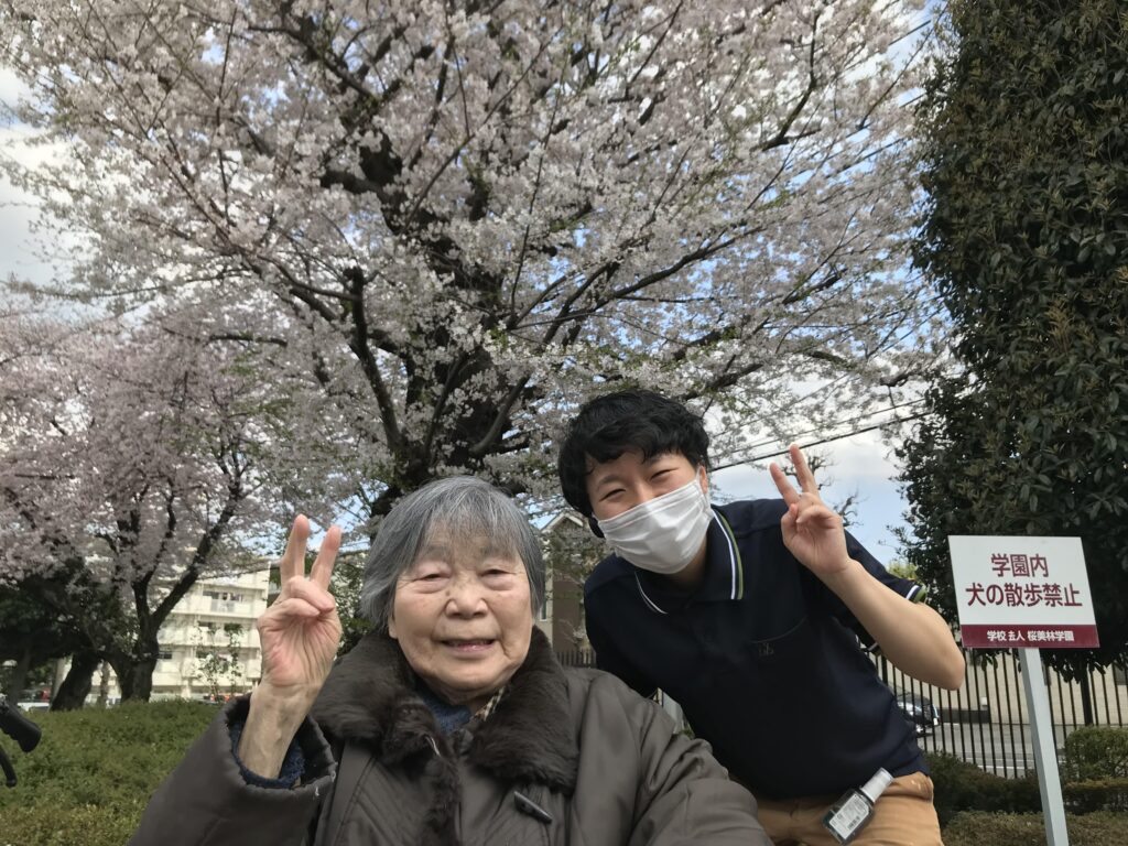 桜をバックに写真を撮る女性二人
