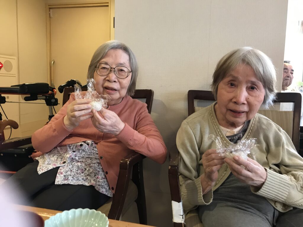 餅を丸める女性二人