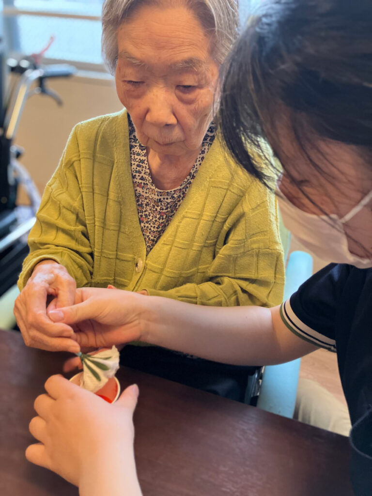 真剣な表情でカーネーション制作する女性