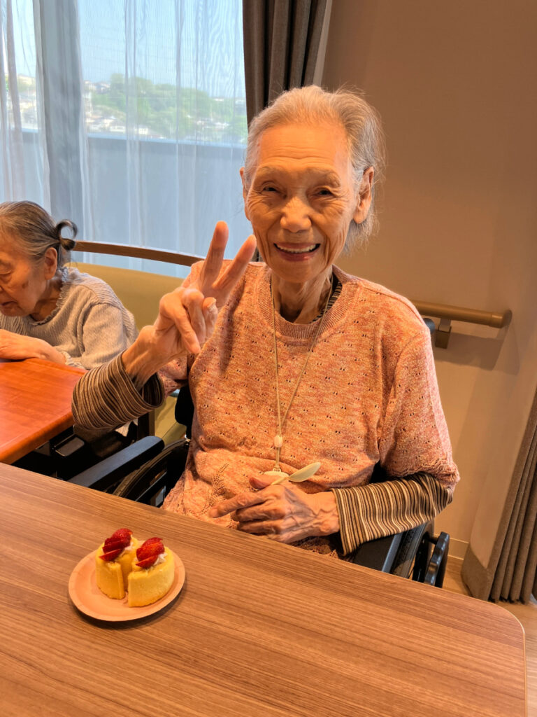 ケーキとピースする女性
