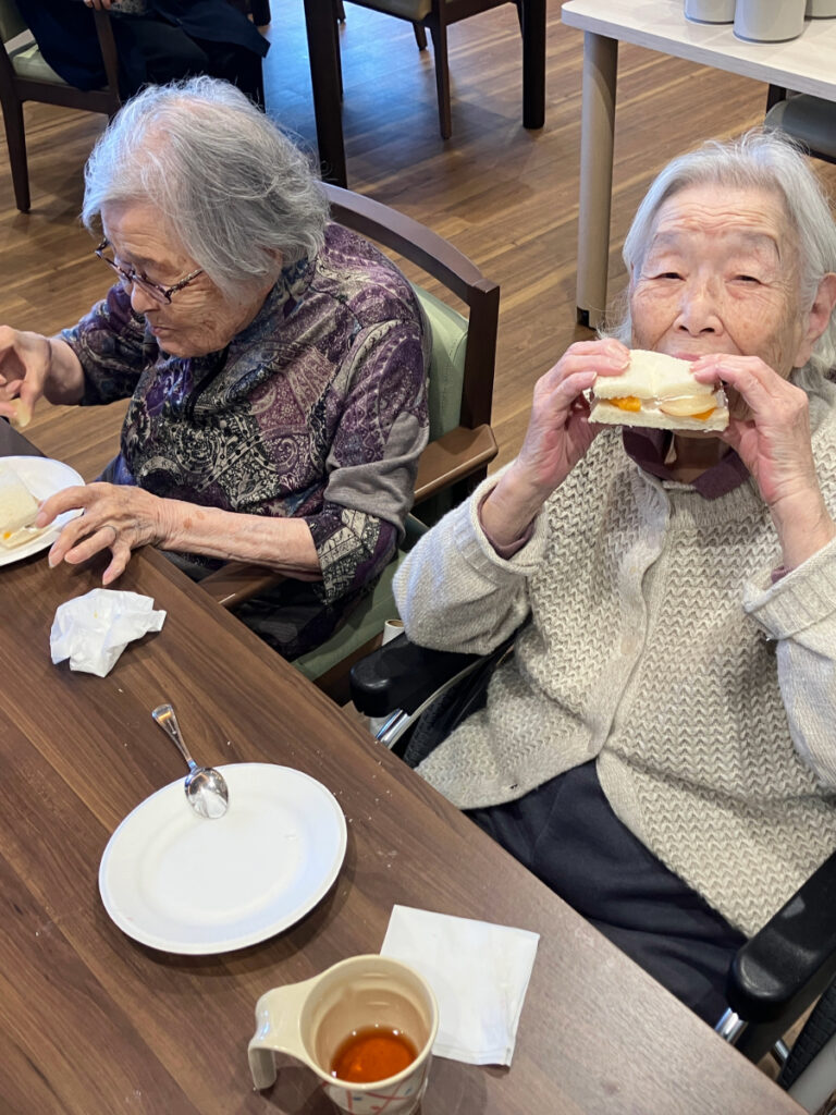 フルーツサンドを頬張る女性
