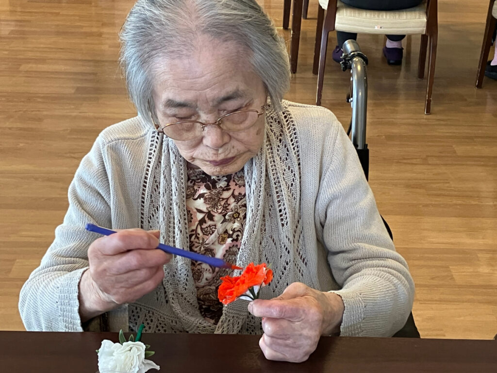 真剣な表情でカーネーション制作する女性