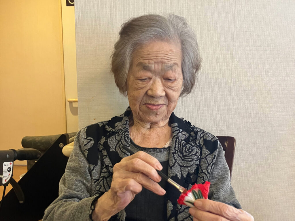 真剣な表情でカーネーション制作する女性