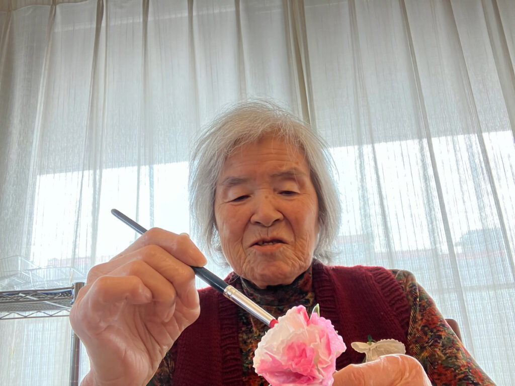 真剣な表情でカーネーション制作する女性