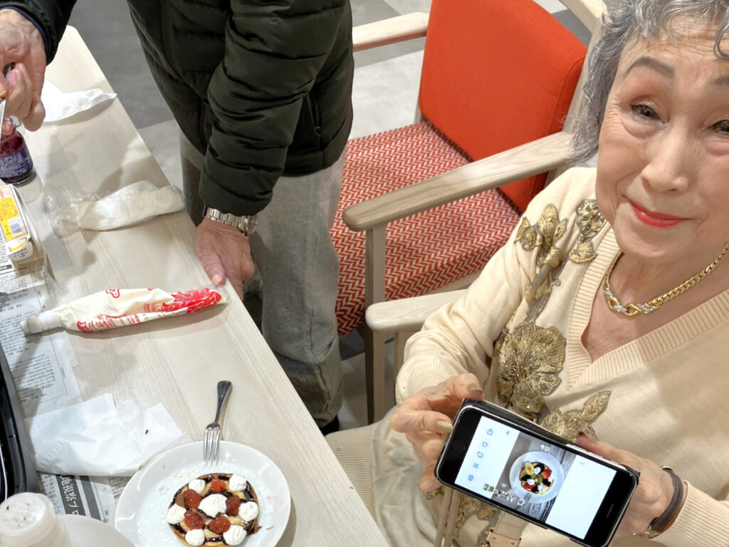 ご自身でつくったホットケーキを写真に撮り笑顔の女性