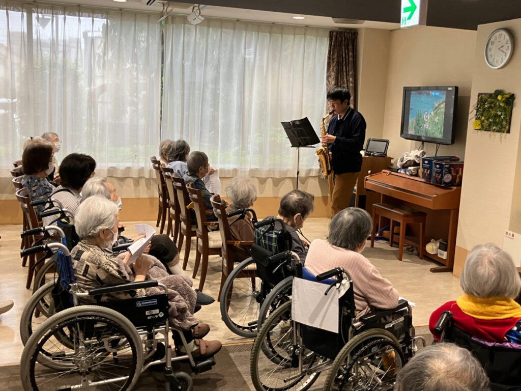 サックスで演奏を披露する新卒スタッフ