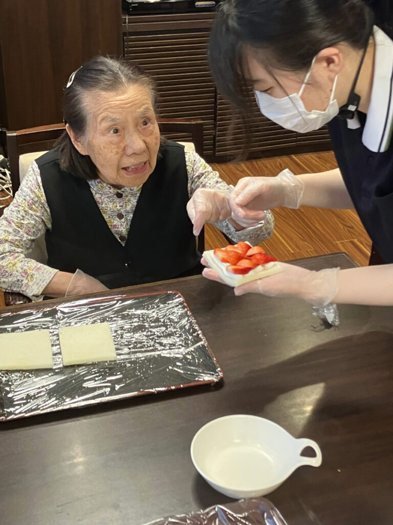 おやつレクリエーション スタッフと会話しながら作る様子