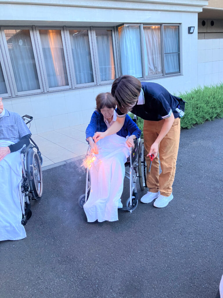 手持ち花火を楽しむご入居者とスタッフ