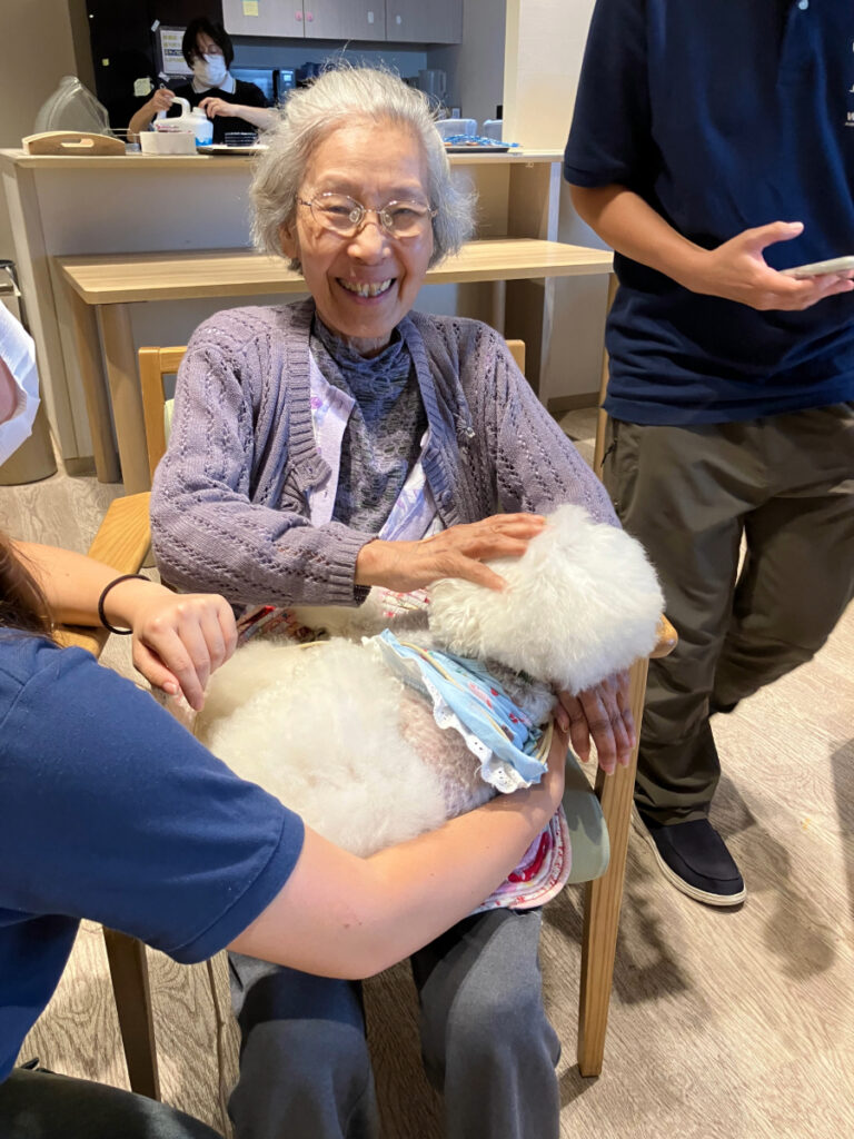 ワンちゃんを膝に乗せ満面の笑顔のご入居者