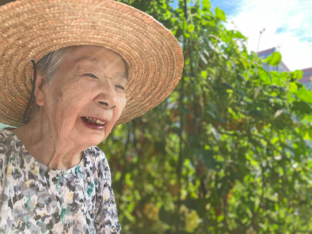 麦わら帽子を被って夏のひざしを楽しむご入居者