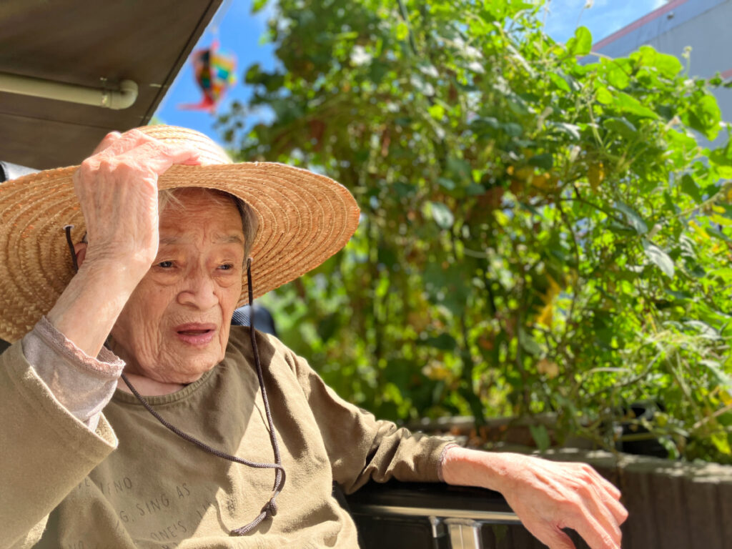 麦わら帽子を被って夏のひざしを楽しむご入居者