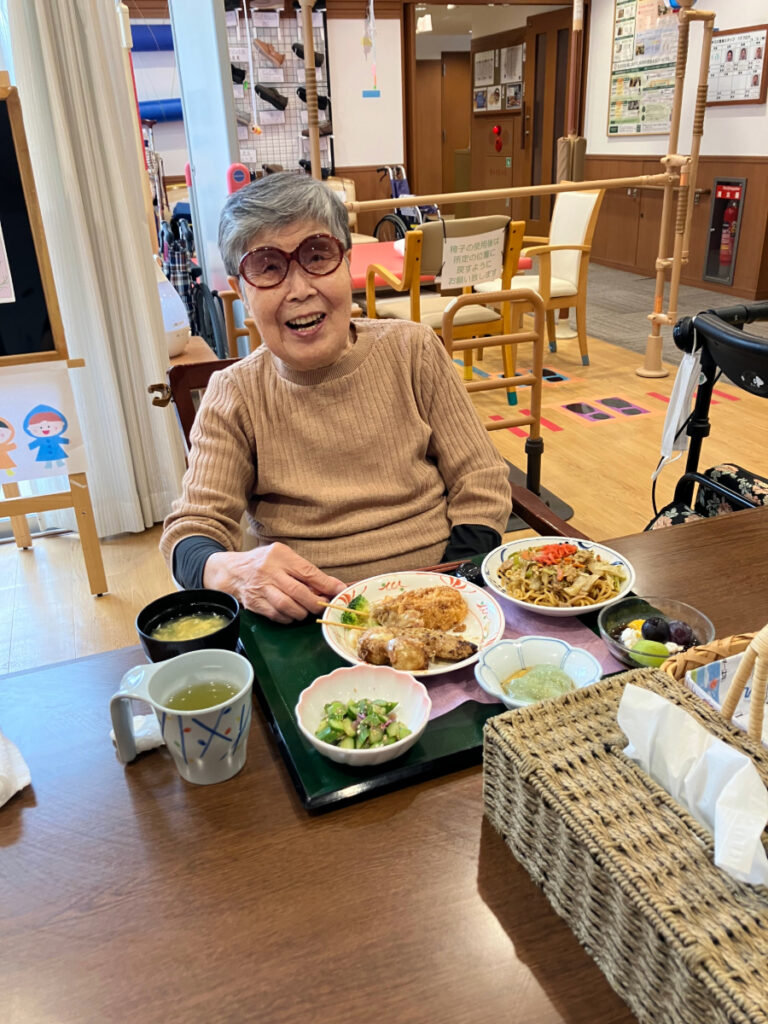 納涼祭で屋台メニューのやきどばを食べるご入居者
