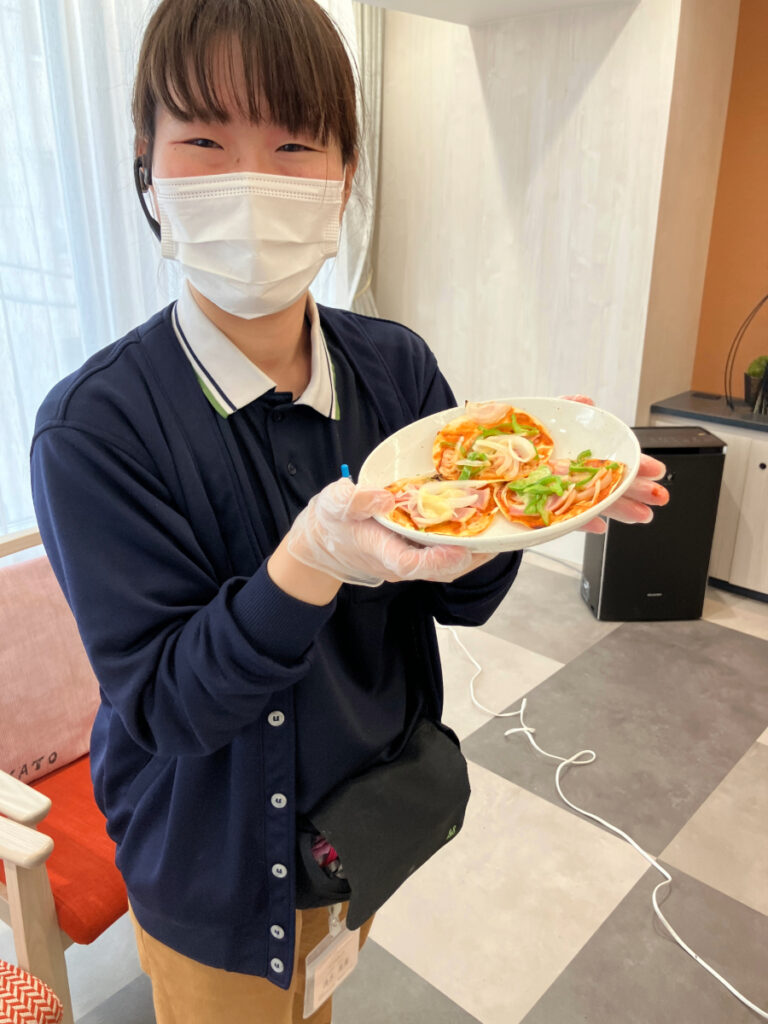 出来立てのピザを持ってにっこり
