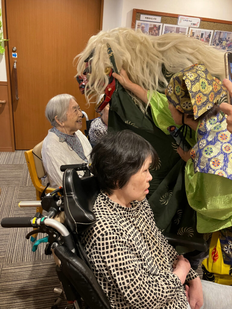 獅子舞にかみつかれそうになり笑顔のご入居者