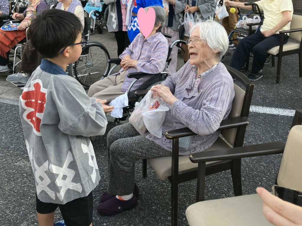 子供神輿のお礼にお菓子を手渡すご入居者