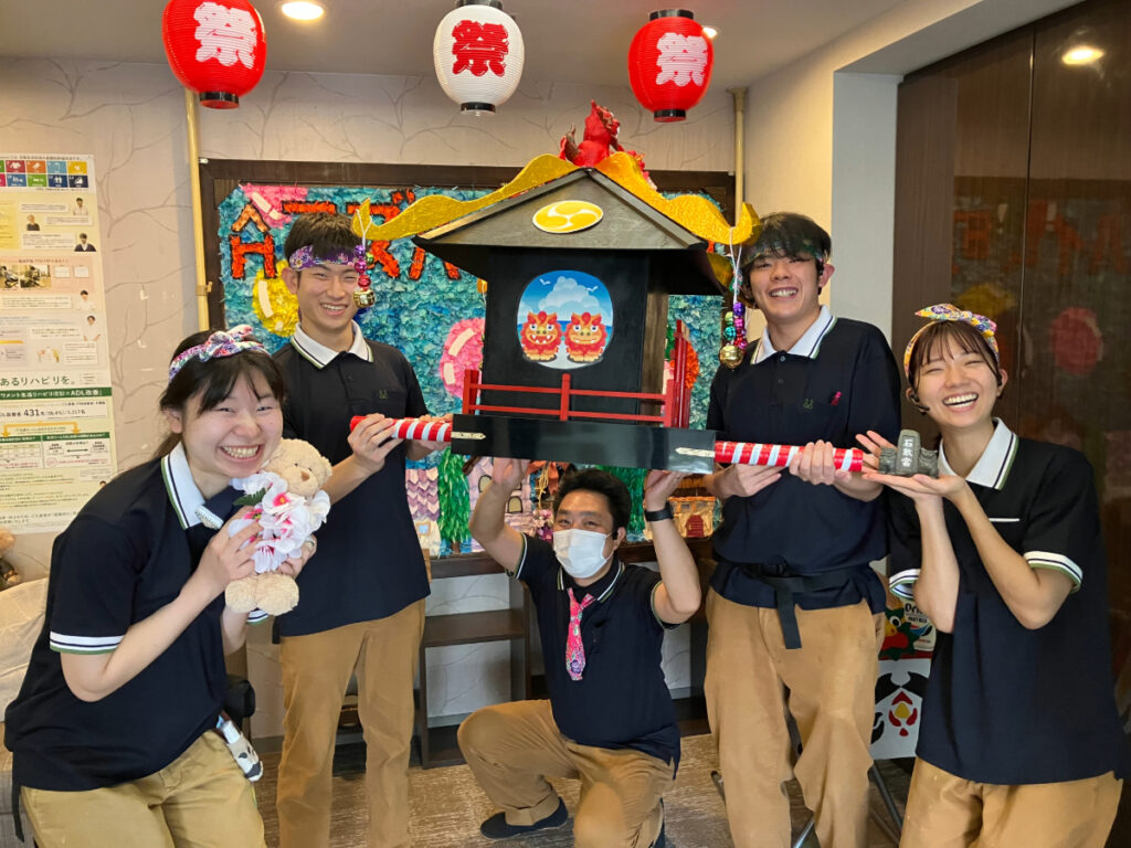 豊穣祭で手作り神輿を担ぐスタッフ