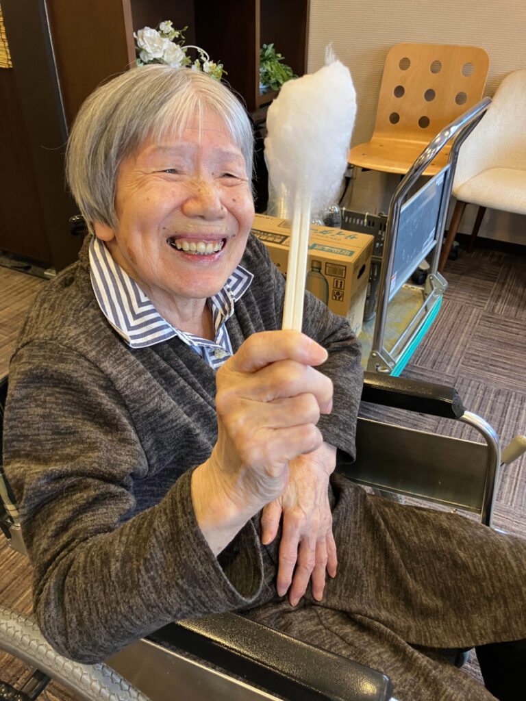 秋祭り　綿あめを手に最高の笑顔のご入居者