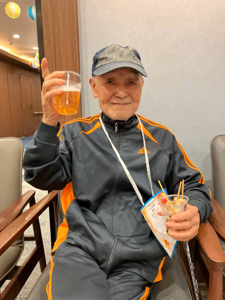 屋台グルメの焼き鳥とビールで乾杯するご入居者