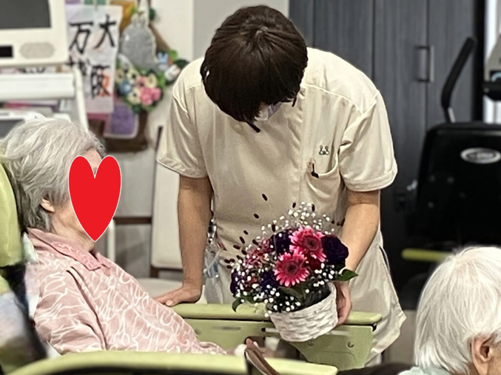 完成したフラワーアレンジメントを見るご入居者