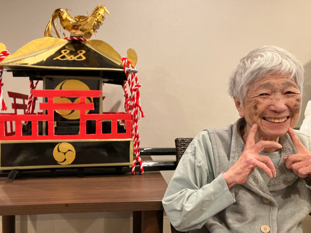 スタッフお手製のお神輿と笑顔のご入居者