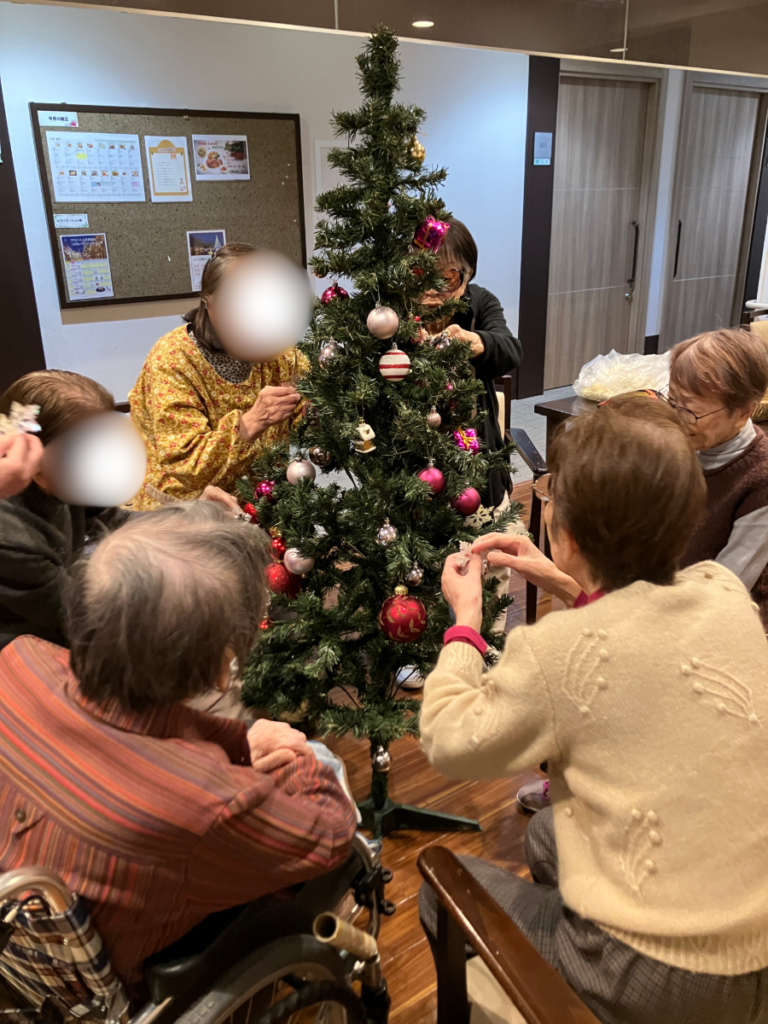 真剣にクリスマスツリーを飾り付けするご入居者
