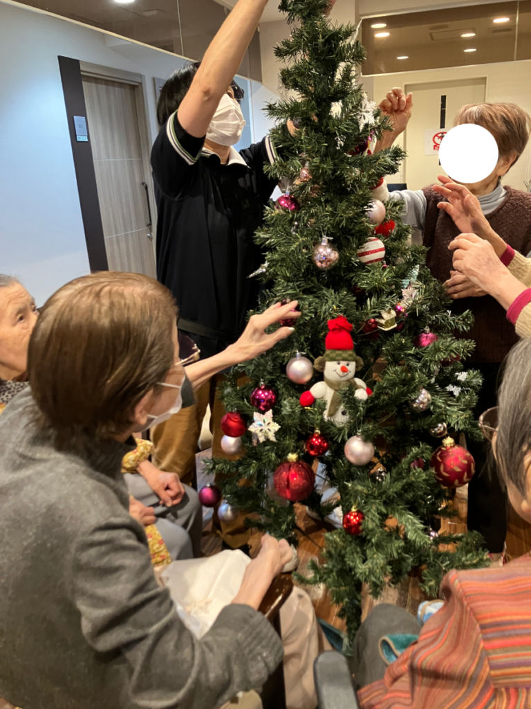 真剣にクリスマスツリーを飾り付けするご入居者