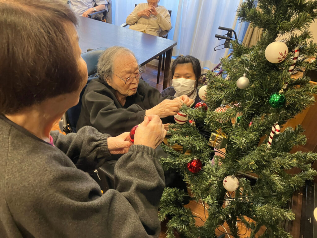 真剣にクリスマスツリーを飾り付けするご入居者