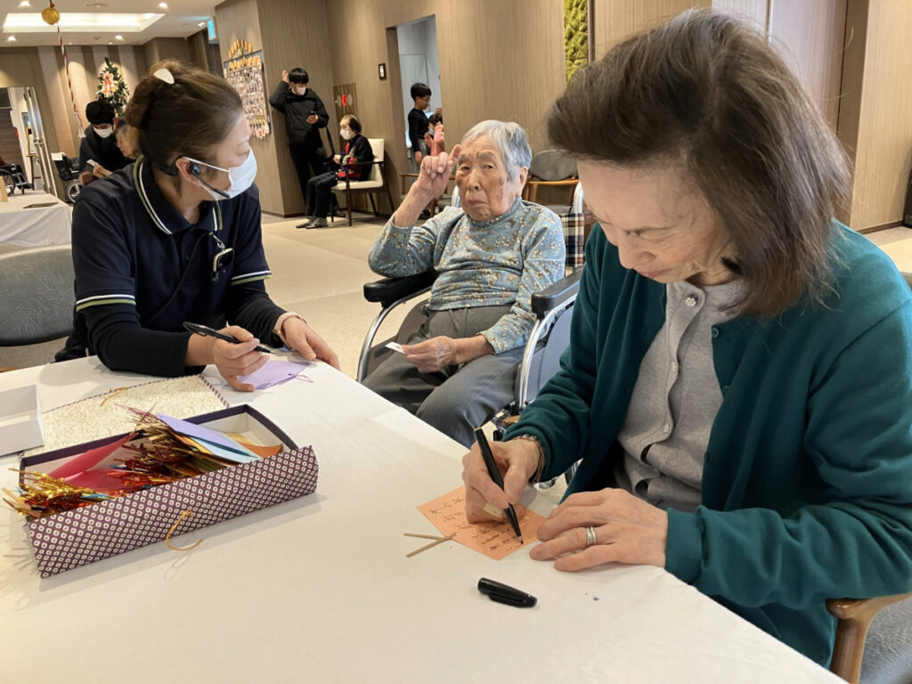 願い事を絵馬に書く様子