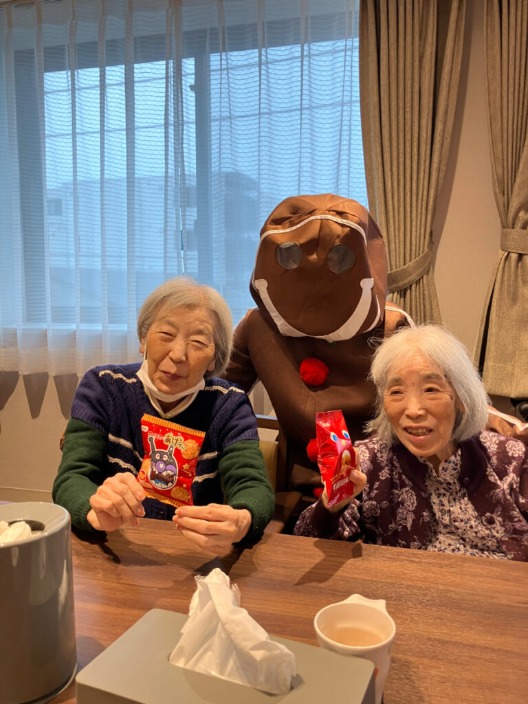 クリスマス　サンタがお菓子を配り笑顔のご入居者