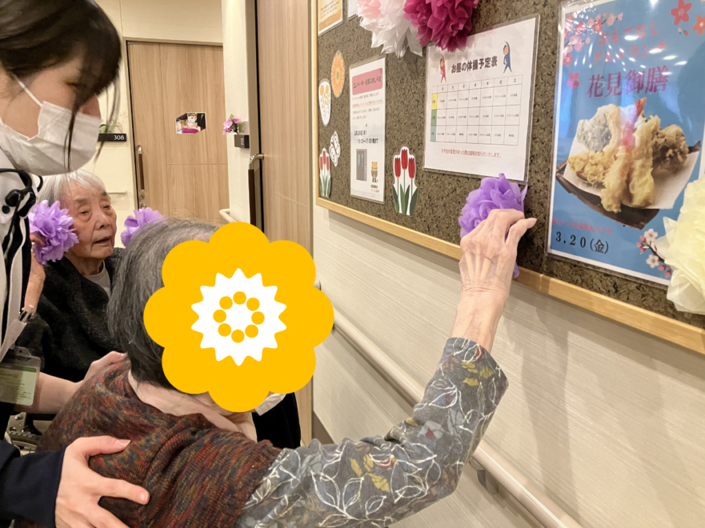 掲示板の飾り付けをするご入居者