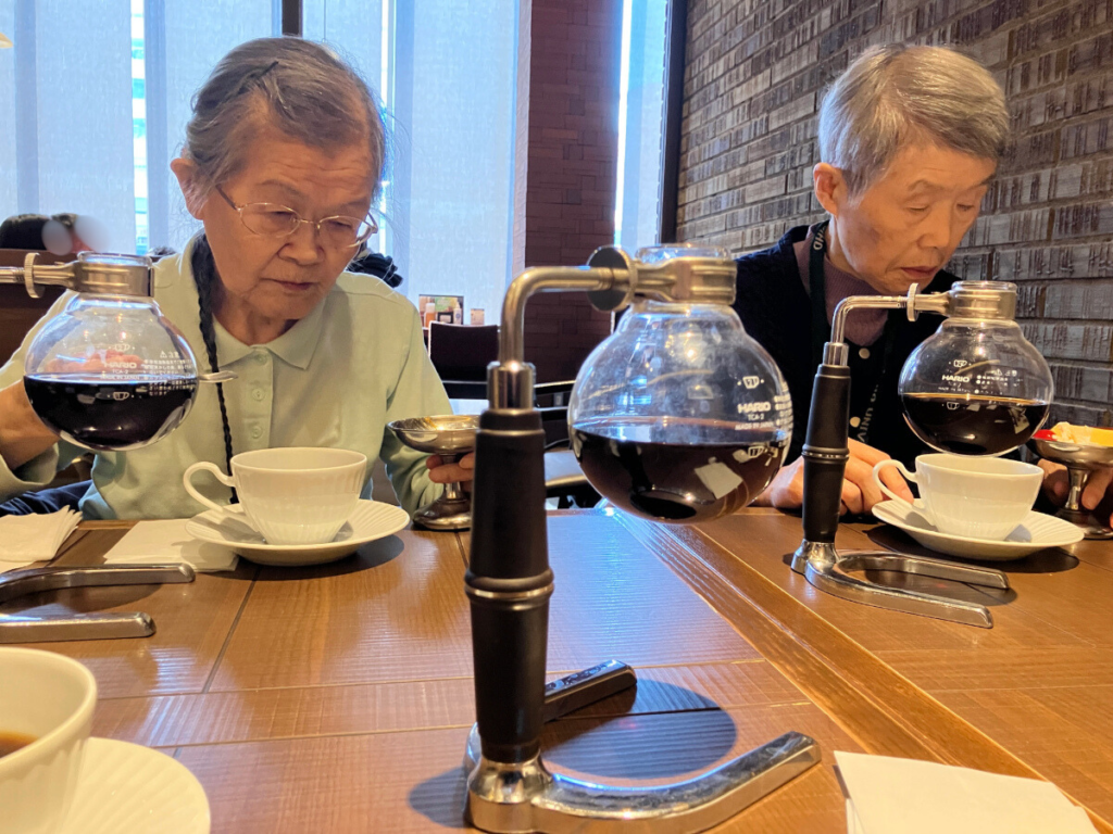 喫茶店でサイフォンコーヒーを楽しむご入居者