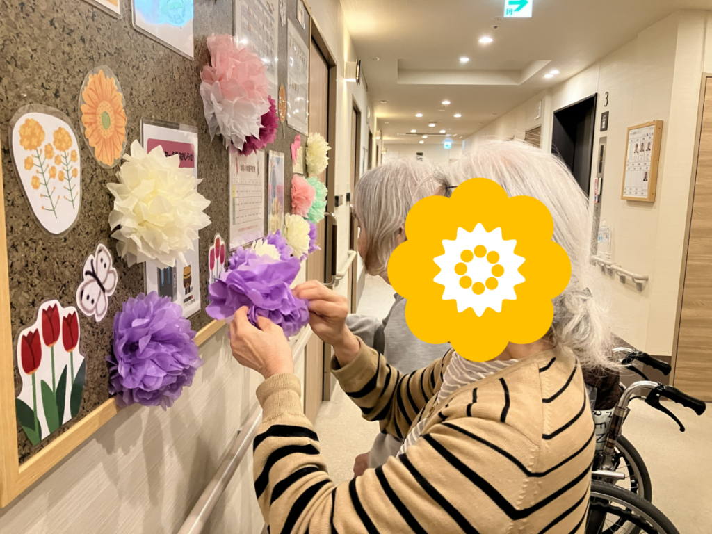 掲示板の飾り付けをするご入居者