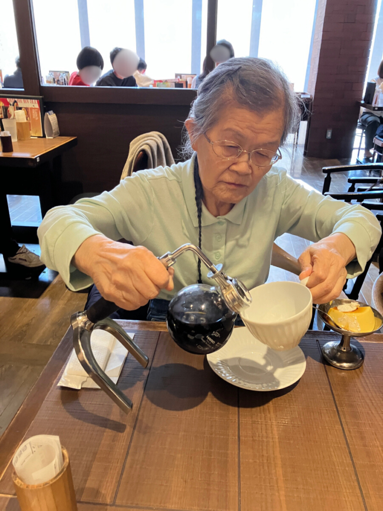 サイフォンコーヒーをカップに注ぐご入居者
