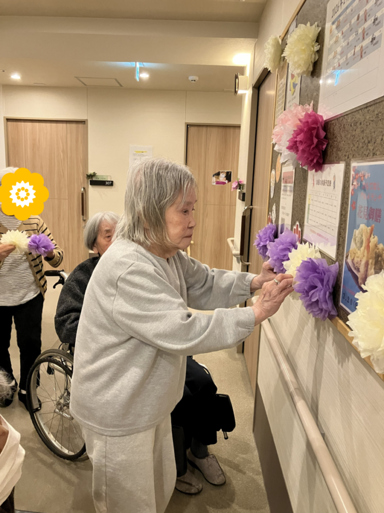 掲示板の飾り付けをするご入居者