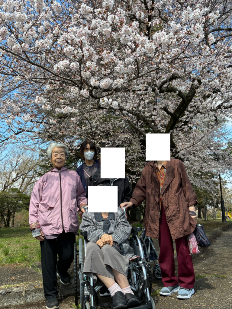 桜の木の下で笑顔のご入居者