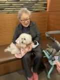 膝の上にワンちゃんを抱っこするご入居者
