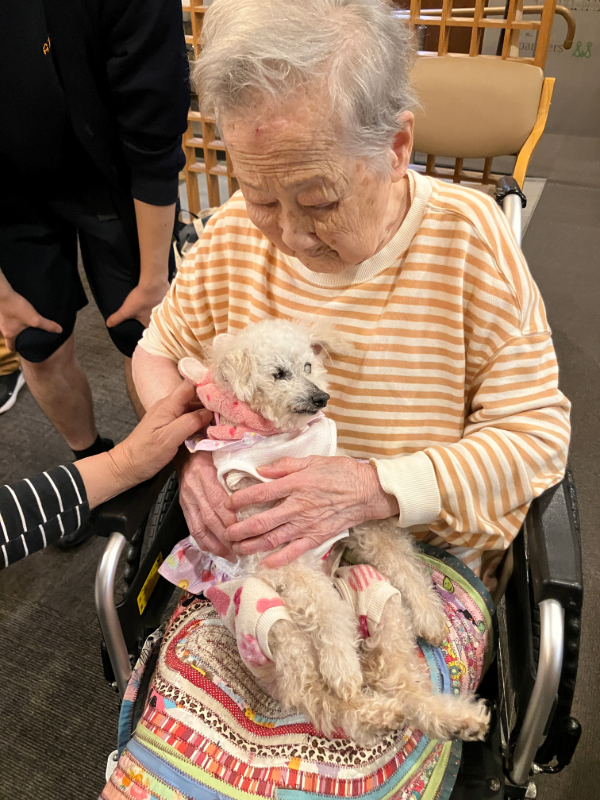 膝の上にワンちゃんを抱っこするご入居者