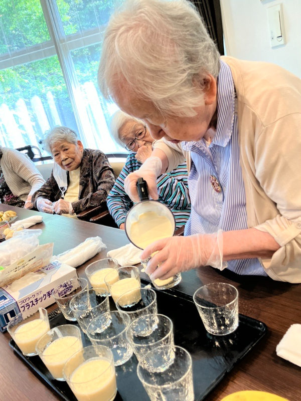 コップに慎重にジュースを注ぐご入居者