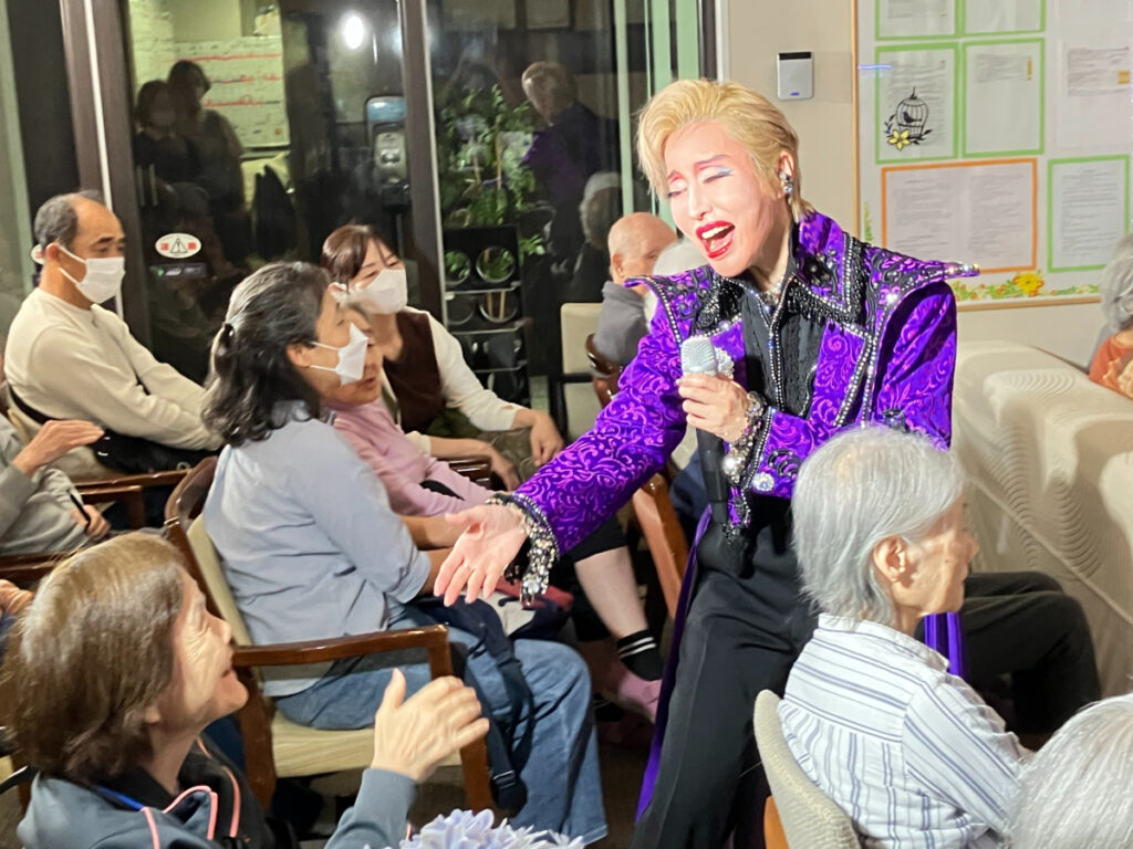 劇団員と握手するご入居者