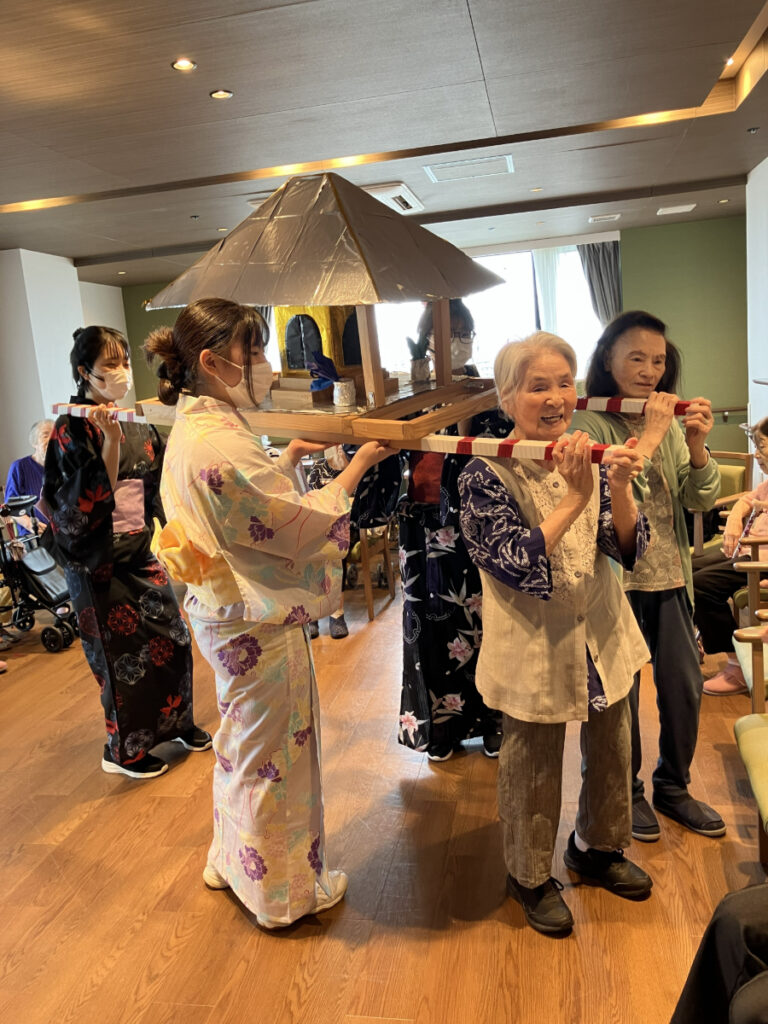 お神輿を担ぐスタッフとご入居者