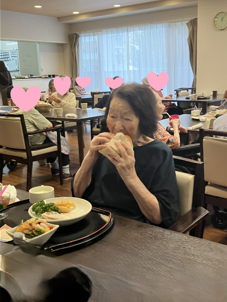 ハンバーガーをガブッと食べるご入居者