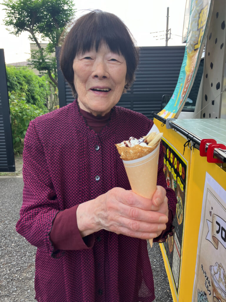 キッチンカーのクレープを受け取り笑顔のご入居者