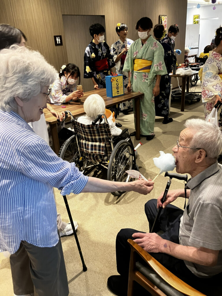 笑顔で綿あめを食べるご入居者