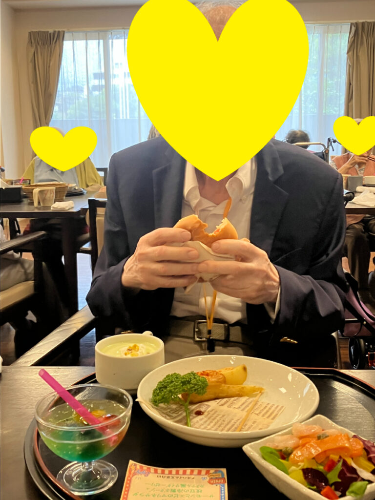 ハンバーガーを笑顔で食べるご入居者