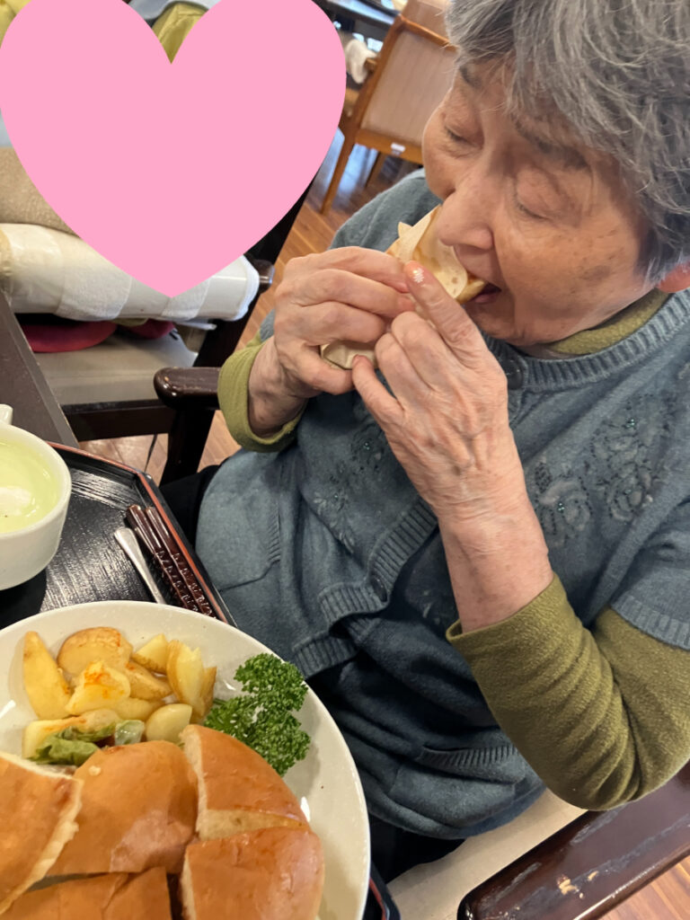 ハンバーガーをガブッと食べるご入居者