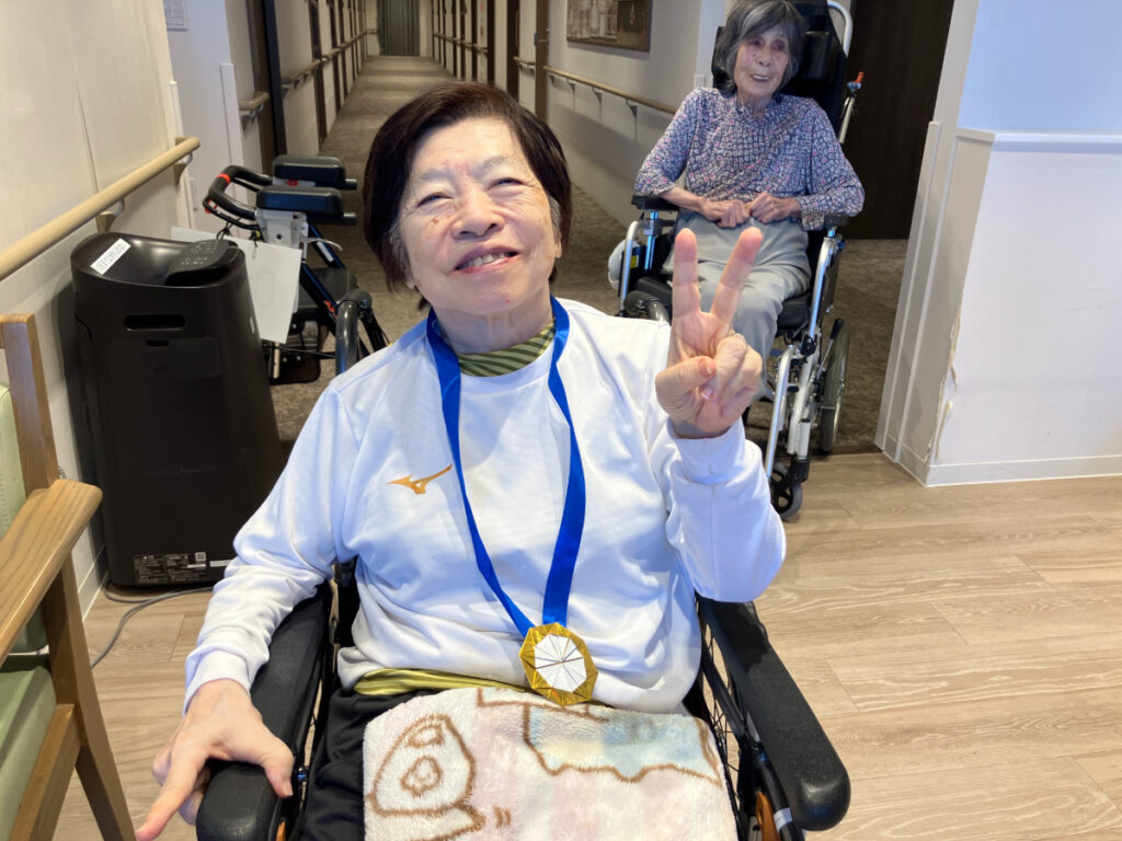 運動会でメダルをもらって笑顔のご入居者