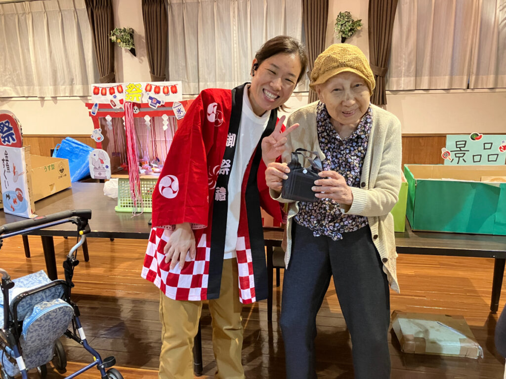 秋祭りで笑顔のご入居者とスタッフ